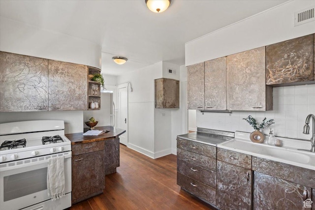 kitchen with dark wood-style flooring, visible vents, backsplash, and white range with gas stovetop