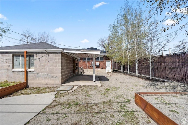 view of yard featuring a garden, a fenced backyard, and a patio area