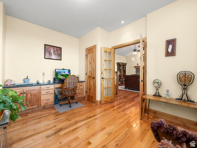 home office with light wood-style flooring, ceiling fan, and baseboards