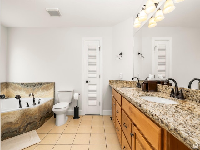 bathroom with tile patterned floors, a closet, a sink, and a garden tub