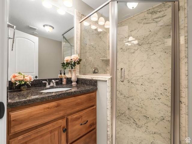 bathroom featuring vanity, a marble finish shower, and visible vents
