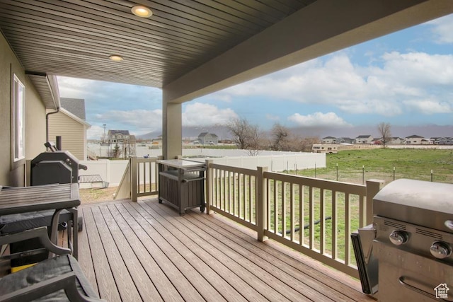 deck featuring a yard, a residential view, grilling area, and a fenced backyard