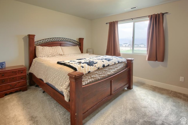 bedroom featuring visible vents, light colored carpet, and baseboards