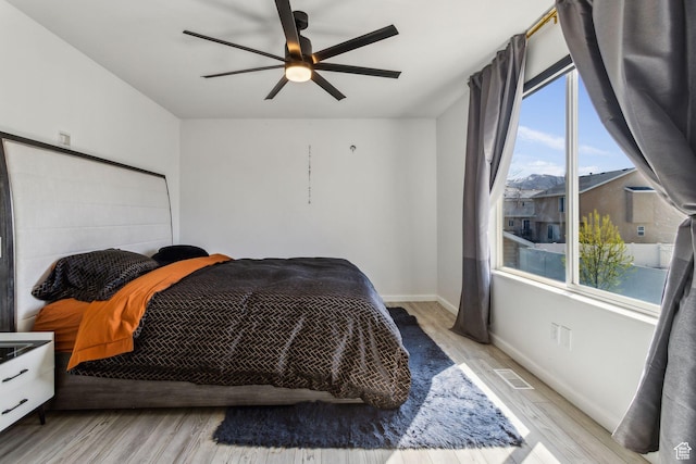 bedroom featuring wood finished floors, ceiling fan, and baseboards