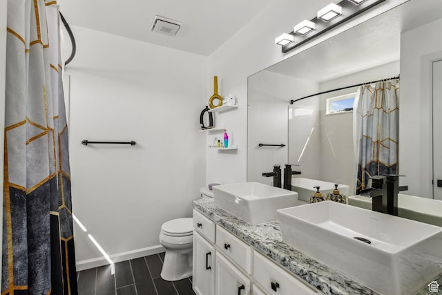 full bathroom with toilet, baseboards, a sink, and visible vents