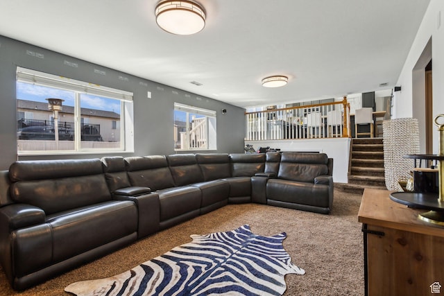 carpeted living room featuring stairway and visible vents