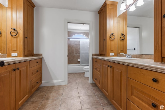 bathroom with tile patterned floors, vanity, baseboards, and toilet