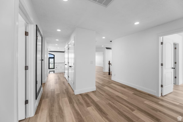 hallway with visible vents, baseboards, light wood-type flooring, and recessed lighting