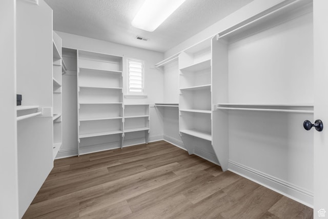 walk in closet with wood finished floors and visible vents