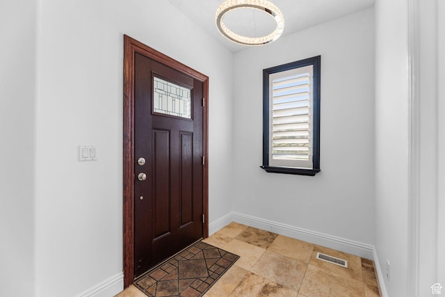foyer entrance with visible vents and baseboards