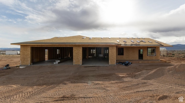 rear view of house with a patio and dirt driveway