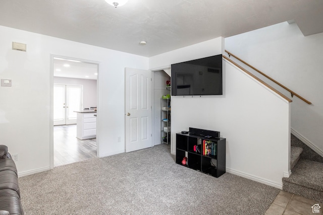carpeted living area with baseboards and stairway