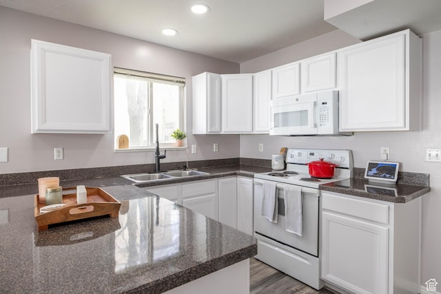 kitchen with white cabinets, white appliances, and a sink