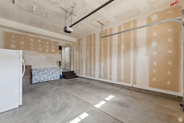 garage with a garage door opener and freestanding refrigerator