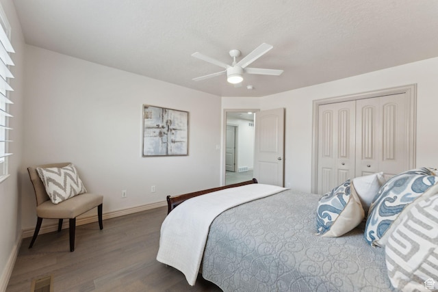 bedroom with ceiling fan, a closet, visible vents, wood finished floors, and baseboards