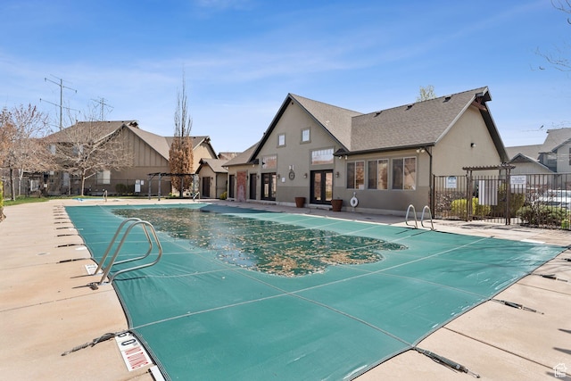 pool with a patio area and fence