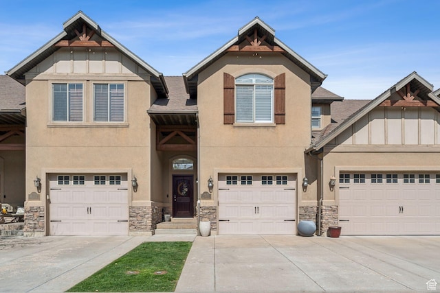 view of front of home featuring stone siding, a garage, driveway, and stucco siding