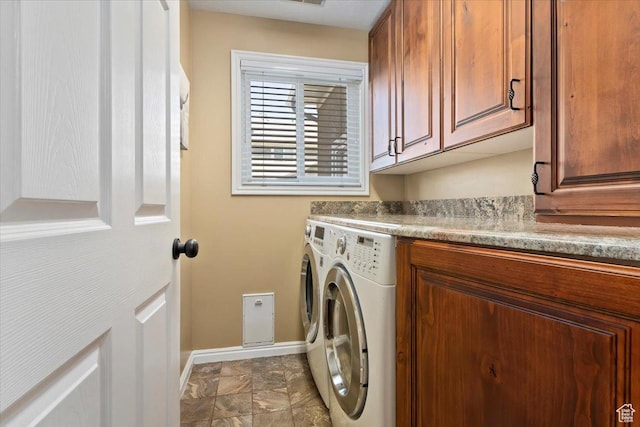 laundry room featuring washer and dryer, baseboards, and cabinet space
