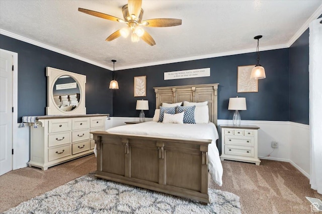 bedroom featuring a textured ceiling, carpet flooring, ceiling fan, and ornamental molding