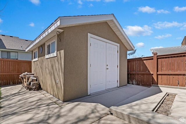 view of outbuilding with a fenced backyard and an outdoor structure