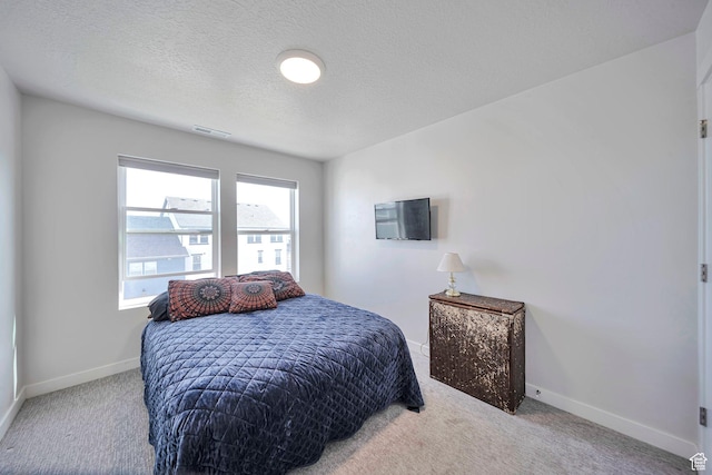 bedroom with a textured ceiling, carpet flooring, baseboards, and visible vents