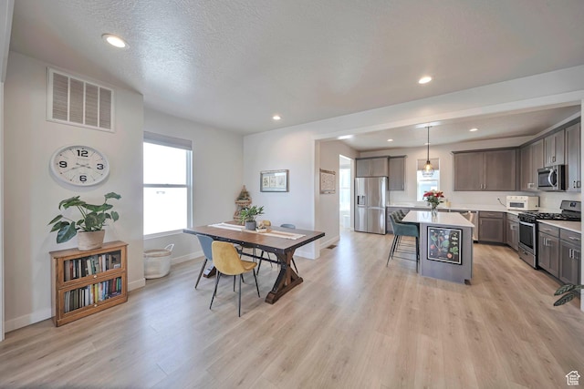 dining area with light wood finished floors, baseboards, visible vents, and recessed lighting