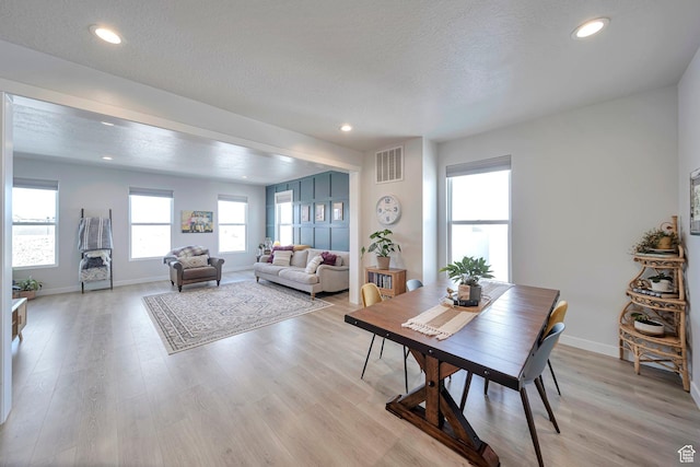 dining space featuring light wood finished floors, baseboards, visible vents, and recessed lighting