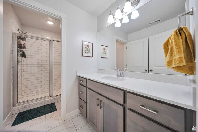 full bath featuring visible vents, baseboards, vanity, marble finish floor, and a stall shower