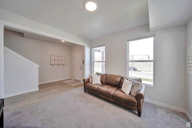 living area with plenty of natural light, baseboards, and a textured ceiling