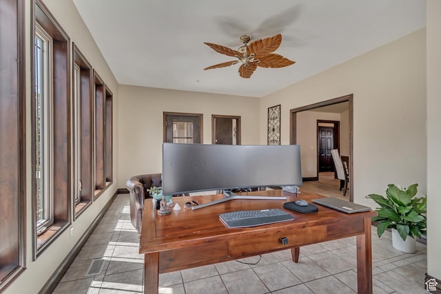 office space featuring light tile patterned floors, visible vents, baseboards, and a ceiling fan