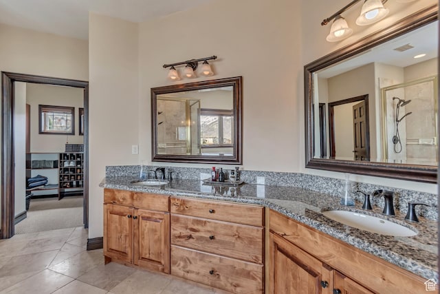 full bathroom featuring a sink, tile patterned floors, a shower stall, and double vanity