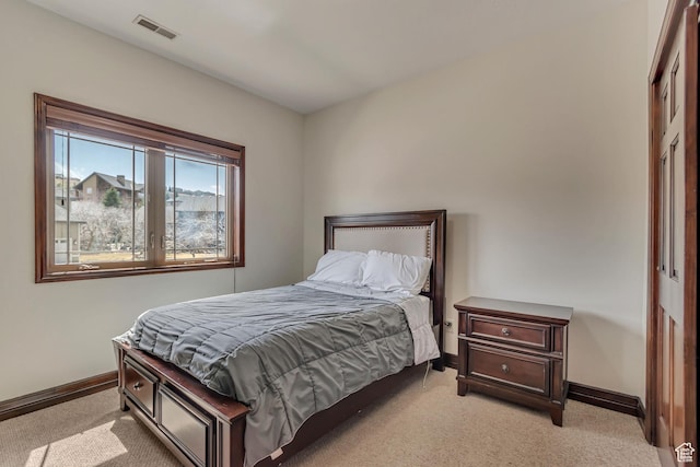 bedroom with visible vents, light colored carpet, and baseboards