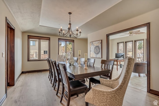 dining room with baseboards, plenty of natural light, and an inviting chandelier