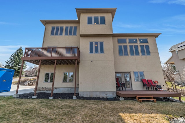 rear view of property with a yard and stucco siding
