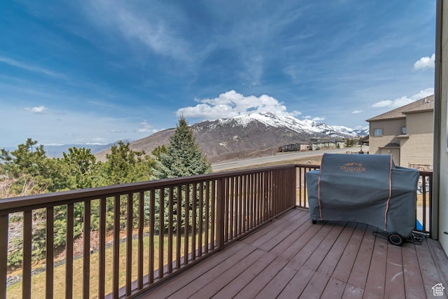 wooden deck featuring a mountain view and a grill