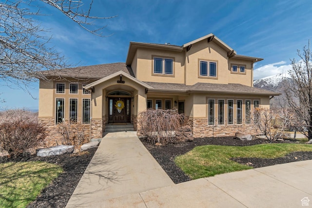 view of front of property featuring stone siding and stucco siding