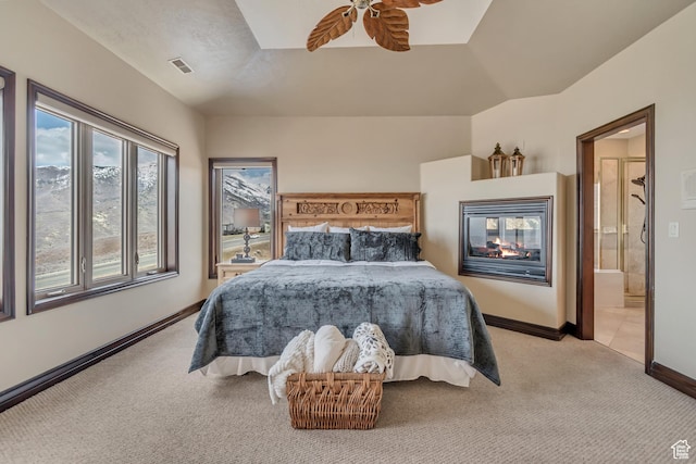 bedroom featuring a multi sided fireplace, light colored carpet, ensuite bath, visible vents, and baseboards
