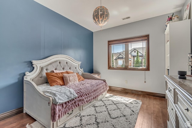 bedroom with baseboards, dark wood-style floors, and visible vents