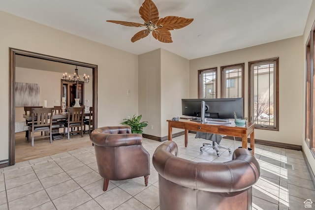 home office featuring ceiling fan with notable chandelier, light tile patterned flooring, and baseboards