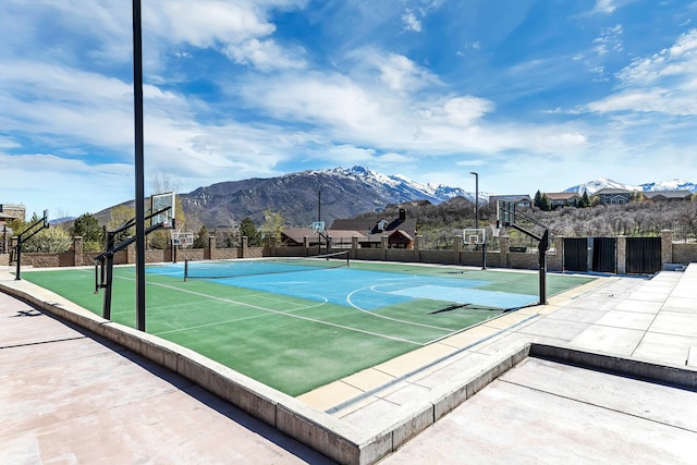 view of basketball court with community basketball court, a mountain view, and fence
