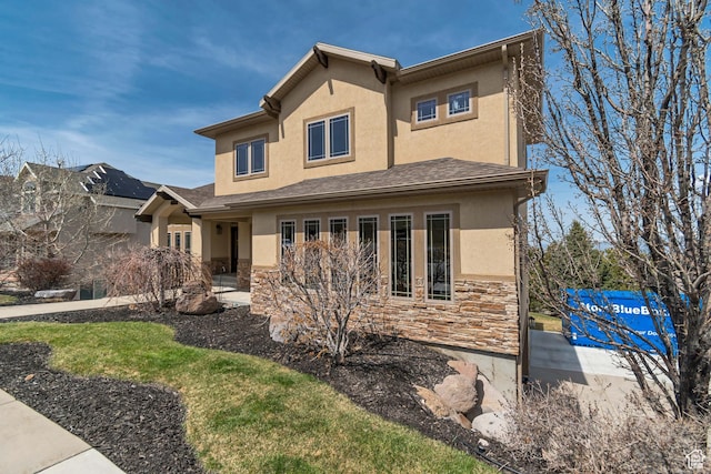 view of front of property featuring a patio area, stucco siding, and stone siding
