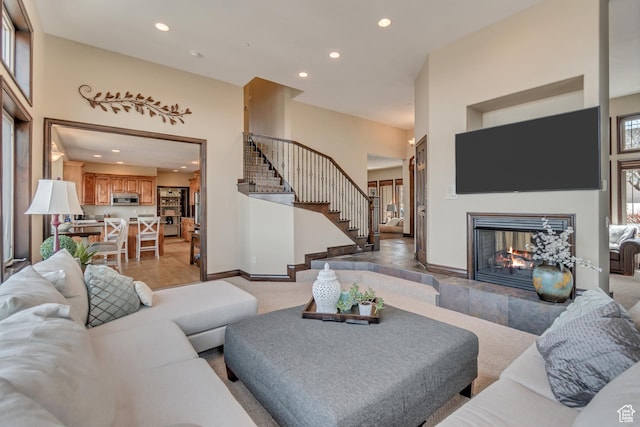 living room featuring stairway, a towering ceiling, and recessed lighting