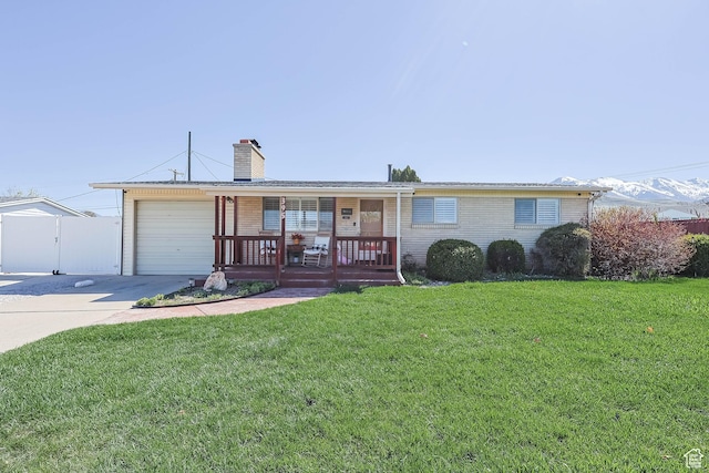 single story home with a front yard, driveway, a garage, and a porch