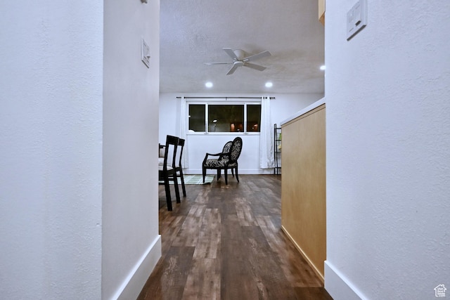 corridor with dark wood-style flooring and baseboards