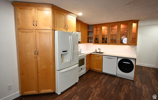 kitchen featuring white appliances, washer / dryer, a sink, and dark wood finished floors
