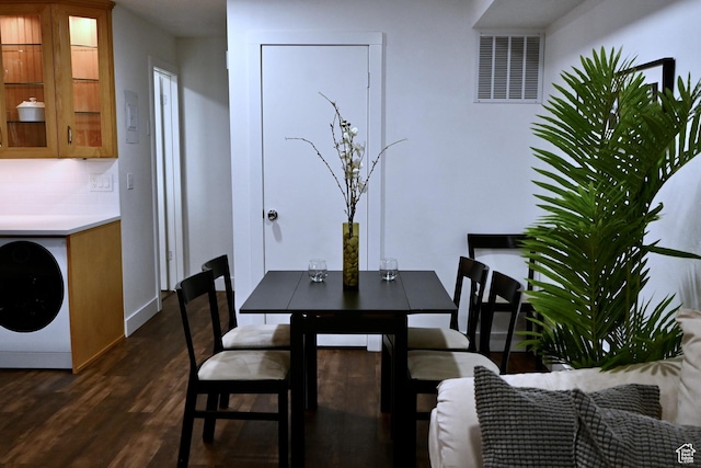 dining space featuring visible vents, washer / clothes dryer, and dark wood finished floors