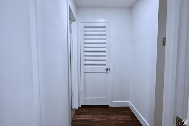 hall featuring baseboards and dark wood finished floors