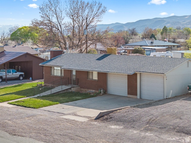single story home with brick siding, a mountain view, and a garage