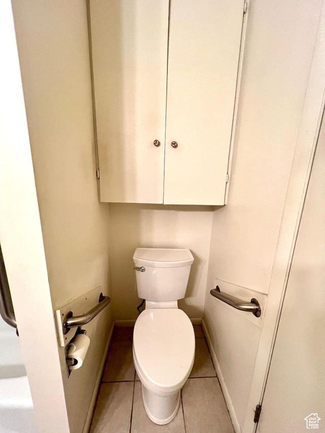 bathroom with toilet, tile patterned floors, and baseboards