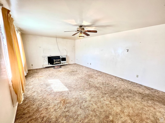 unfurnished living room with ceiling fan and carpet floors
